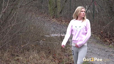 Blonde babe Claudia pisses down a drain outside