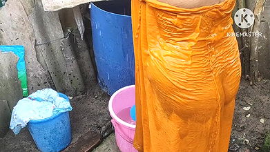 Indian house wife bathing outside with