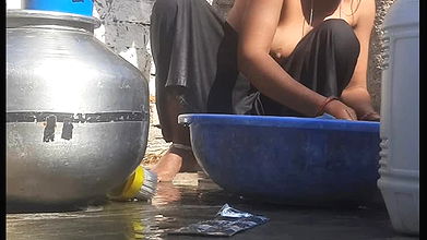 Indian stepsister is preparing to take a bath while washing clothes in the open courtyard of the house